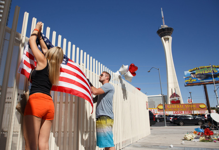 Image: Mourners put up a U.S. flag in Las Vegas