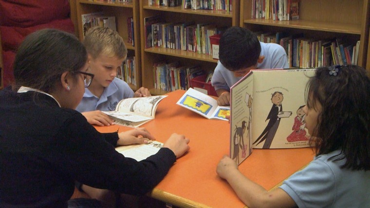 Students read at the Salazar Family Library inside Escuela De Guadalupe in Denver.
