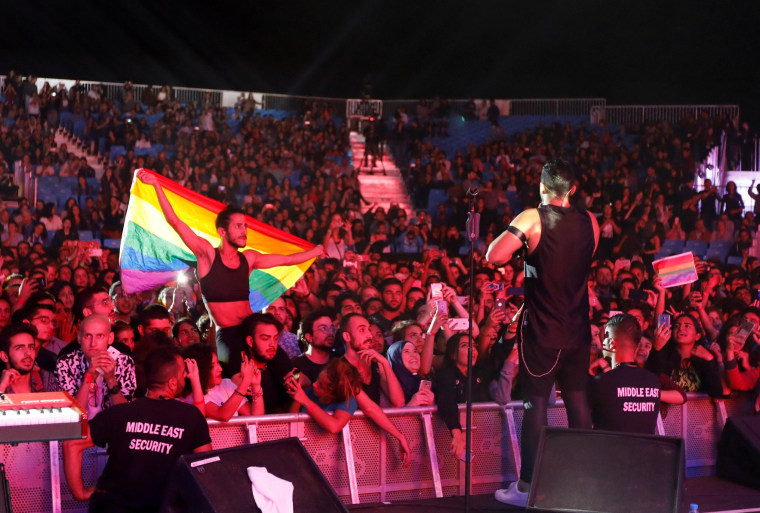 Image: FILE PHOTO:A fan of Lebanese alternative rock band Mashrou' Leila holds a rainbow flag during their concert at the Ehdeniyat International Festival in Ehden town