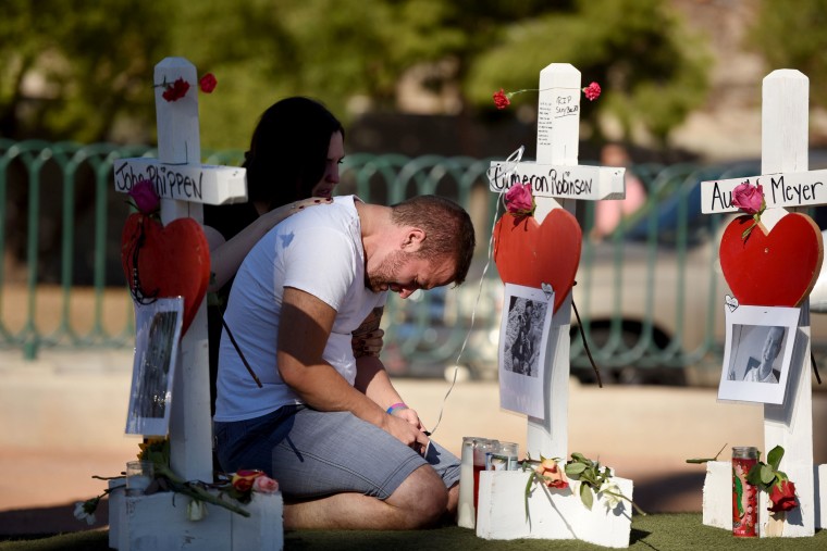 Image: Ethan Avanzino grieves beside a white cross