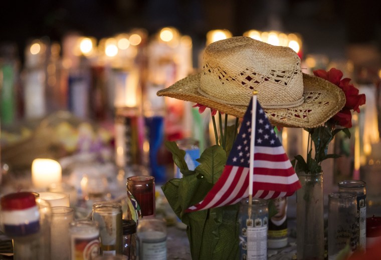 Image: A hat is left at a makeshift memorial during a vigil