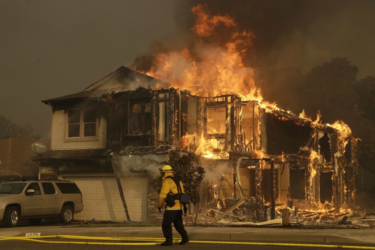 Image: A firefighters walks near a home in Santa Rosa