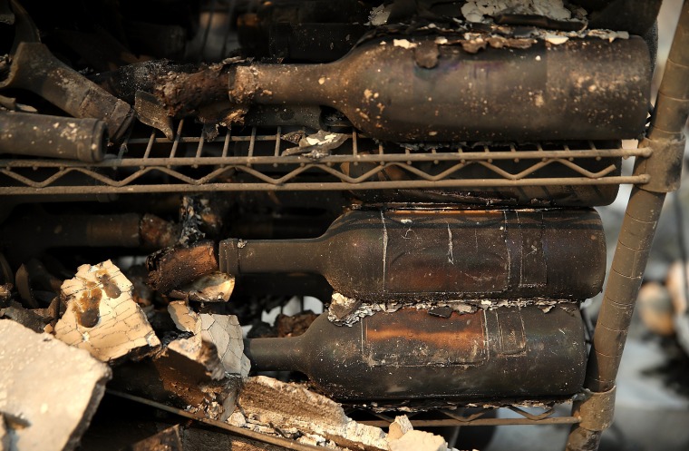Image: Burned out wine bottles sit on a rack at the fire damaged Signarello Estate winery after an out of control wildfire moved through the area