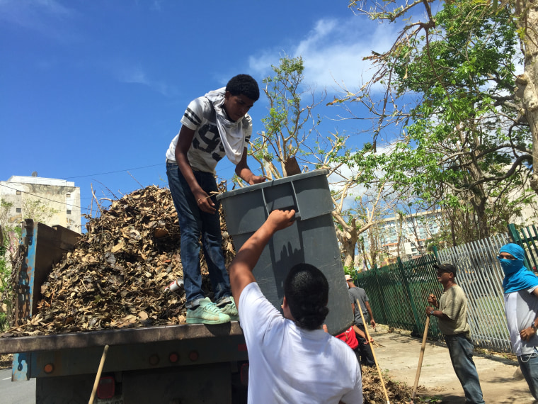 Joshua Jimenez, 19, helps clear debris on October 6, 2017, from streets outside University of Puerto Rico, Rio Piedras.