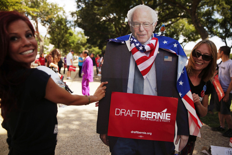 Image: Supporters of Sen. Bernie Sanders hold a cardboard cutout of the senator during a rally