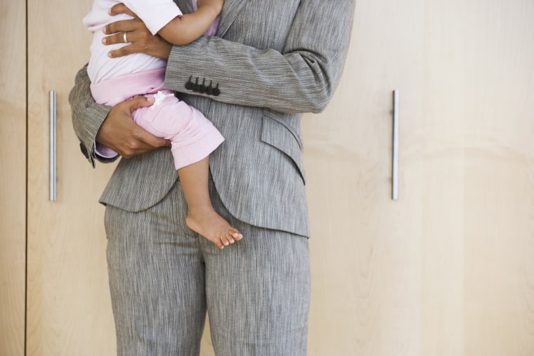 Image: African American businesswoman holding baby