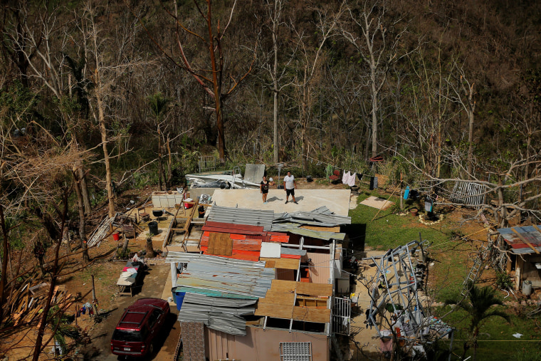 Image: Residents signal that they need water as helicopters fly past during recovery efforts