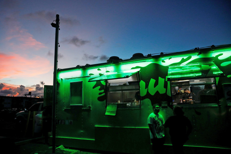 Image: People wait in line for food at a food truck being run by a generator at an area affected by Hurricane Maria in San Juan