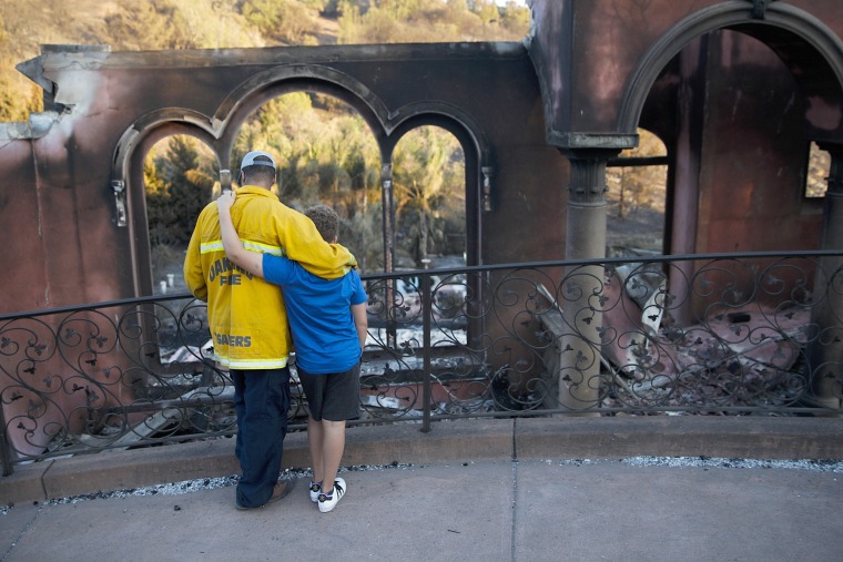 Image: Firefighter and son in front of neighbor's home