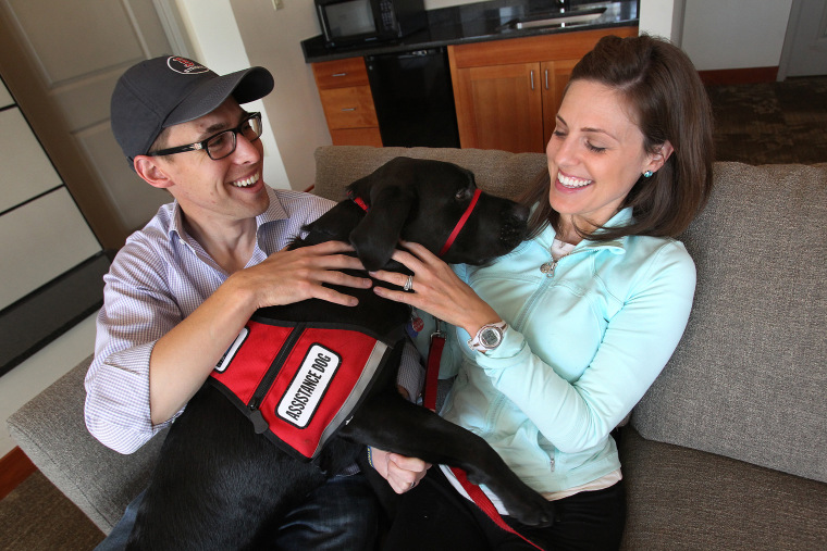 Jessica Kensky and her husband, Patrick Downes, cuddle with Rescue the dog. 