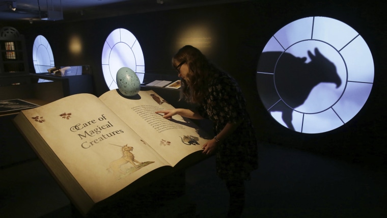 A member of British Library staff poses for a picture at the "Harry Potter - A History of Magic" exhibition at the British Library, in London, Wednesday Oct. 18, 2017