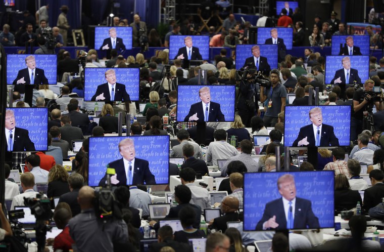 Image: Trump is seen on screens in the media center during the presidential debate
