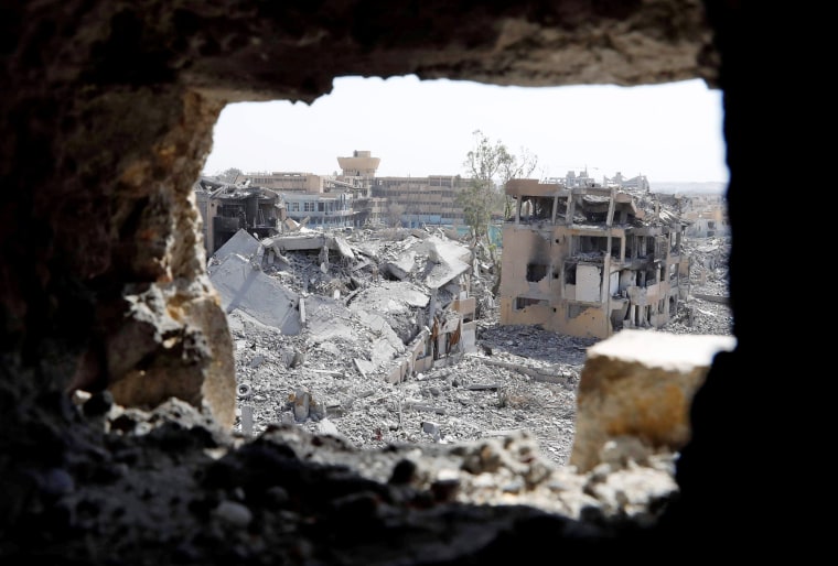 Image: The National Hospital, last stronghold of the Islamic State militants, is pictured from a hole at the positions of the Syrian Democratic Forces at the frontline in Raqqa