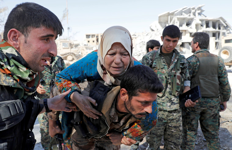 Image: Fighters of Syrian Democratic Forces evacuate a civilian from the stadium after Raqqa was liberated from the Islamic State militants in Raqqa