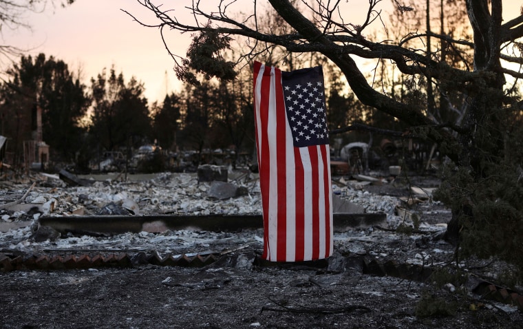 Image: An American flag hangs from a tree in a neighborhood destroyed by wildfire in Santa Rosa, California, U.S.