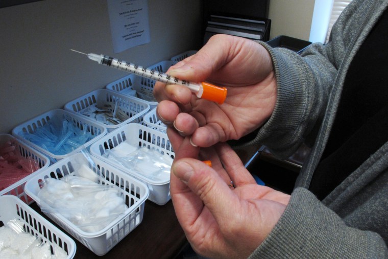 Image: A public health nurse holds one of the syringes provided to intravenous drug users