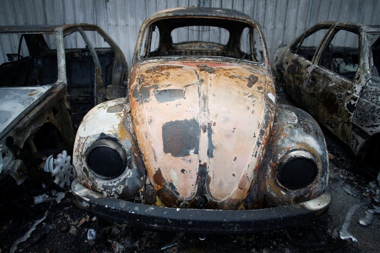 Image: Burnt vehicles are seen after a forest fire in Miro, near Penacova