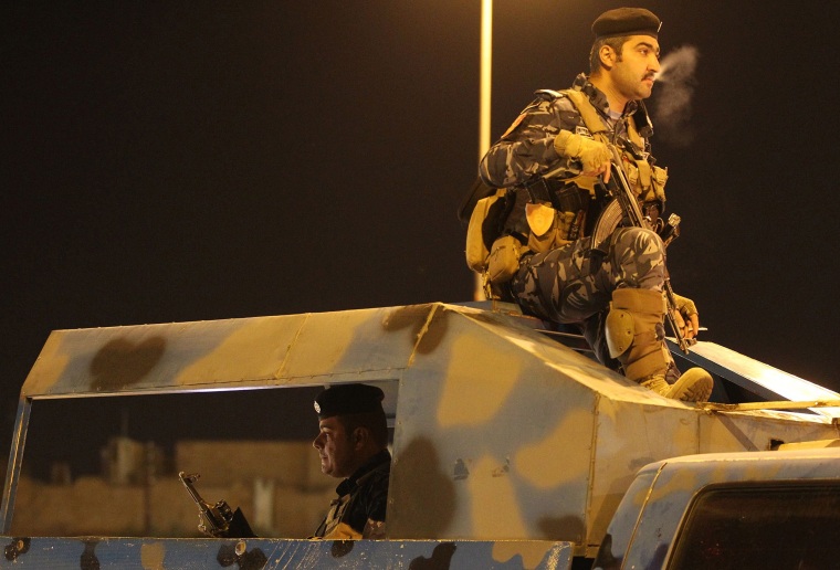 Image: Iraqi police monitor as people gather in the street in the city of Kirkuk