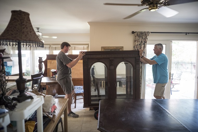 Image: Rick Christie and his son Dalton move furniture