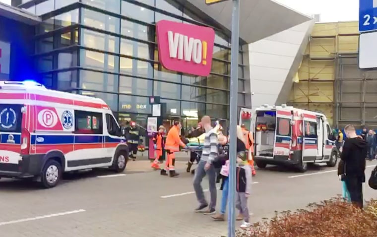 Image: Emergency services transport a victim to an ambulance following an attack at a mall in Stalowa Wola, Poland