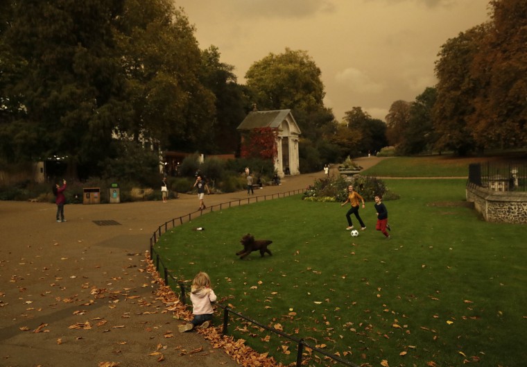 Image: Hyde Park is bathed in a dull sepia light from the sky in London