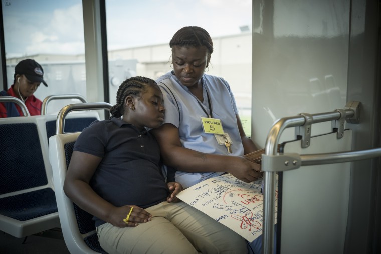 Image: Ebony Harrison and her daughter take the train to visit Harrison's infant daughter