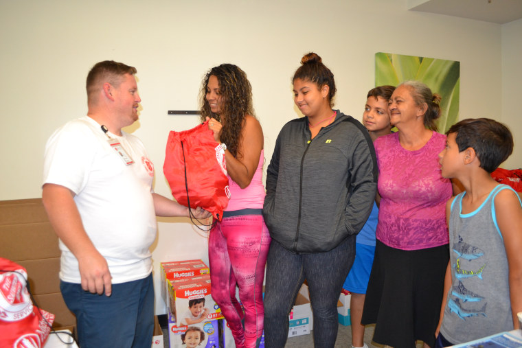 Raymond Boyd, a mission specialist with the Salvation Army, assists Melissa Nogueras and her family at the hurricane relief center in Miami International Airport on October 20, 2017.