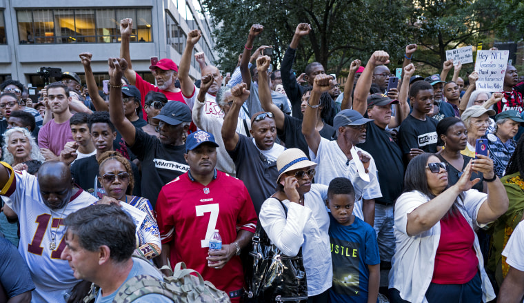 People raise their arms as hey gather in support of unsigned NFL quarterback Colin Kaepernick on Wednesday, Aug 23, 2017, in front of NFL headquarters in New York.