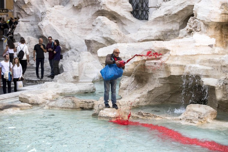 Image: Graziano Cecchini pours red paint in the water of the Trevi Fountain, in Rome