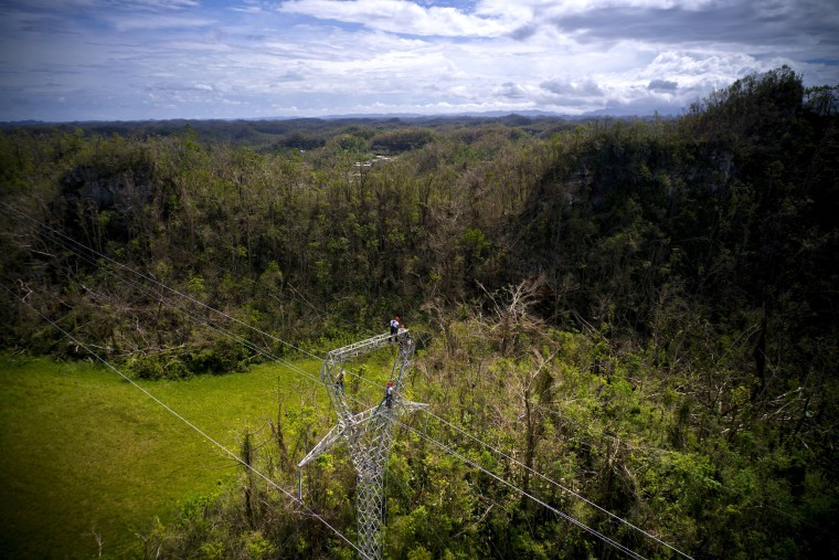 Image: Whitefish Energy Holdings workers stand on towers to restore lines damaged by Hurricane Maria in Barceloneta