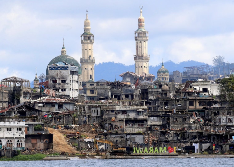 Image: A signage of \"I love Marawi\" is seen in front of damaged houses, buildings and a mosque inside a war-torn Marawi city