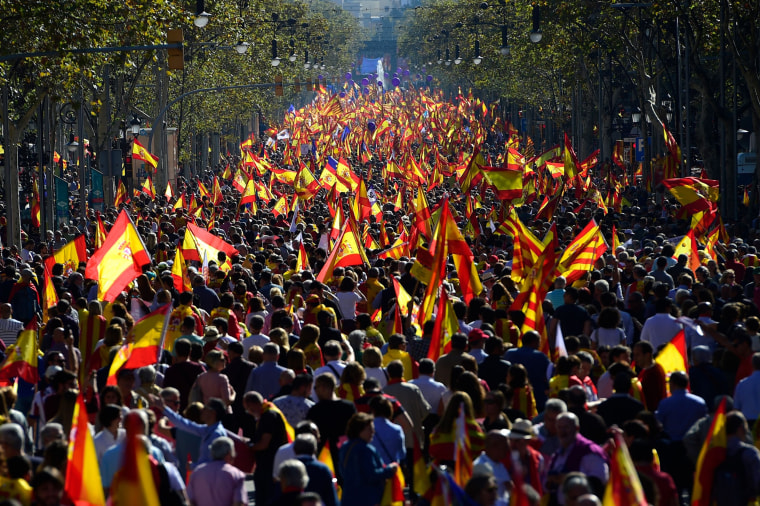 Image: People wave Spanish and Catalan Senyera flags during a pro-unity demonstration in Barcelona