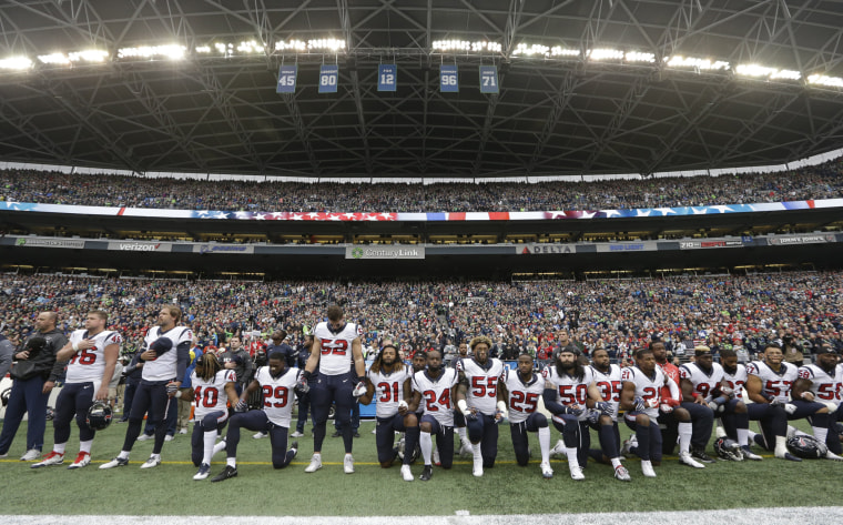 Image: Houston Texans players kneel and stand during the singing of the national anthem before an NFL football game