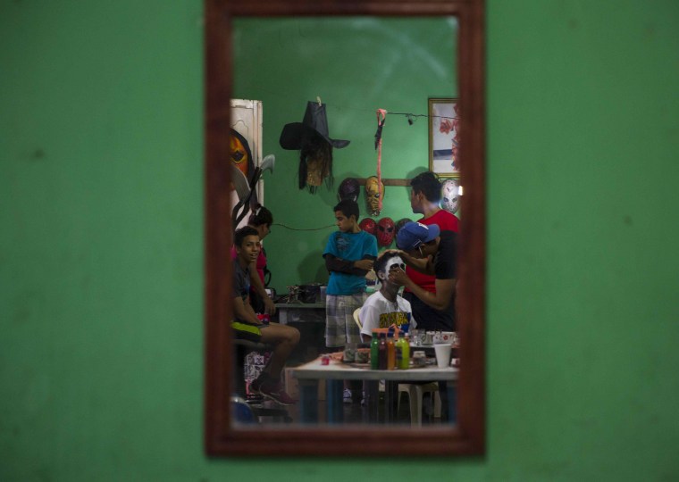 Image: A mirror reflects a man getting his face painted in a workshop during the celebration of the 'Los Aguizotes' holiday in Masaya, Nicaragua on Oct. 27.
