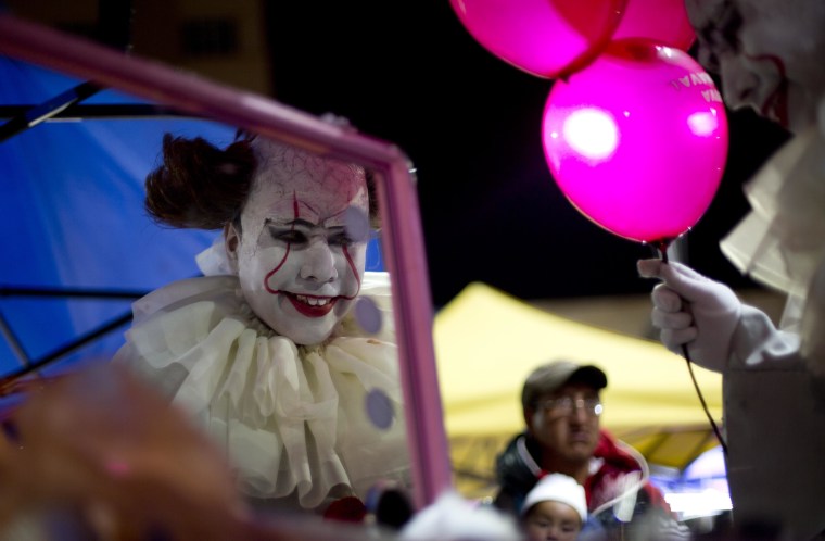Image: A person dressed in a diabolical clown costume looks in the mirror at the start of the Zombie Walk in La Paz, Bolivia, Oct. 28.