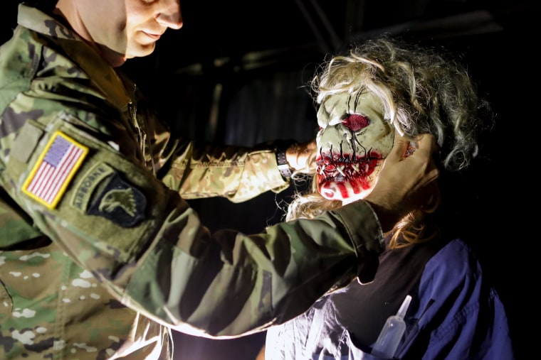 Image: A U.S. soldier serving in the NATO peace keeping mission in Kosovo helps his friend to adjust a mask while taking part in a Halloween party at the U.S. military camp Bondsteel in the village of Sojeve, near the town of Ferizaj, Kosovo on Oct. 29.