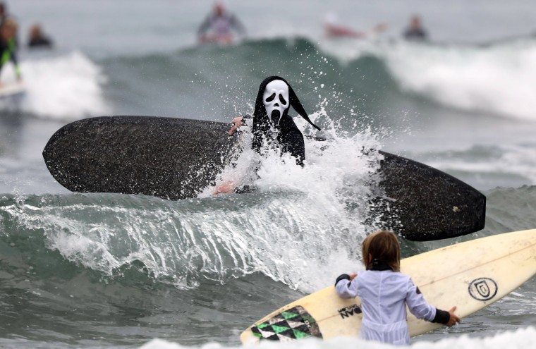 Image: A surfer dressed in a costume from the movie 'Scream' hits the waves during the annual Blackies Halloween Surf Contest in Newport Beach, California, on Oct. 28.