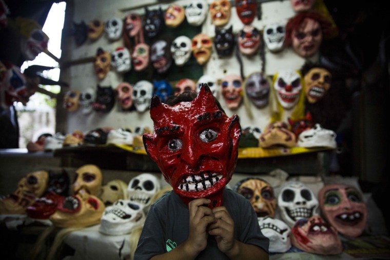 Image: A boy wears a devil's mask as he poses for a photograph in a craft workshop for masks during the celebration of the 'Los Aguizotes' in Masaya, Nicaragua on Oct. 27.