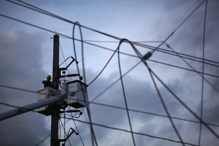 Image: A worker of Puerto Rico's Electric Power Authority (PREPA) repairs part of the electrical grid after Hurricane Maria hit the area in September, in Manati