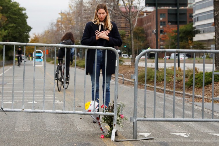 Image: Caroline Ventura looks down at flowers she laid for victims of Tuesday's attack outside a police barricade on the bike path next to West Street in New York City