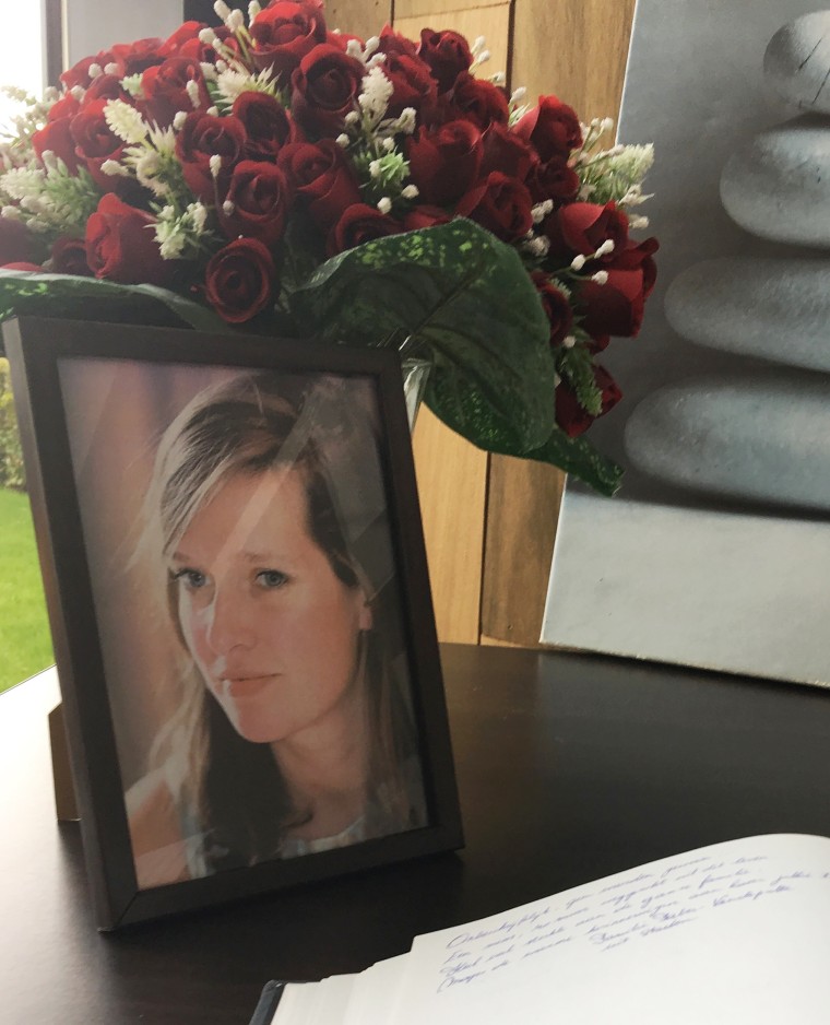 Image: A book of condolence is open next to a portrait of Ann-Laure Decadt in a community center in Staden, Belgium