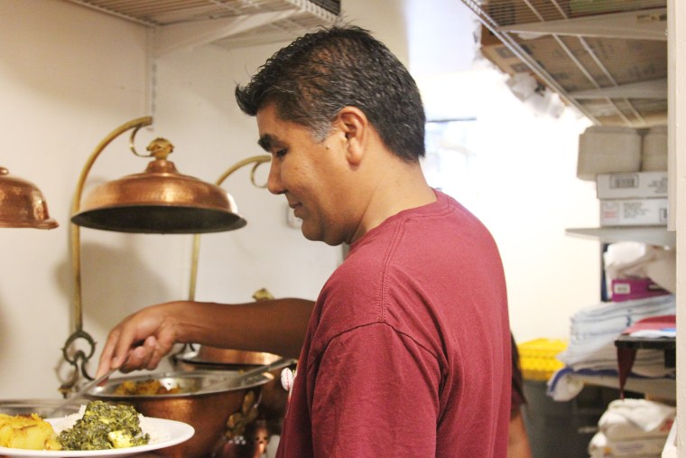 Karma Kitchen D.C. Coordinator Krishna Desar serves a meal for a guest during their October operation.