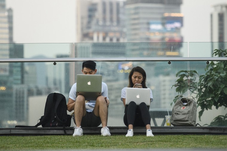 Image: People use their laptops at a park in Hong Kong