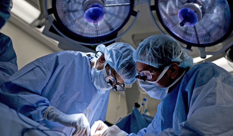 Image: Dr. Niraj Desai (L) sews in a kidney to