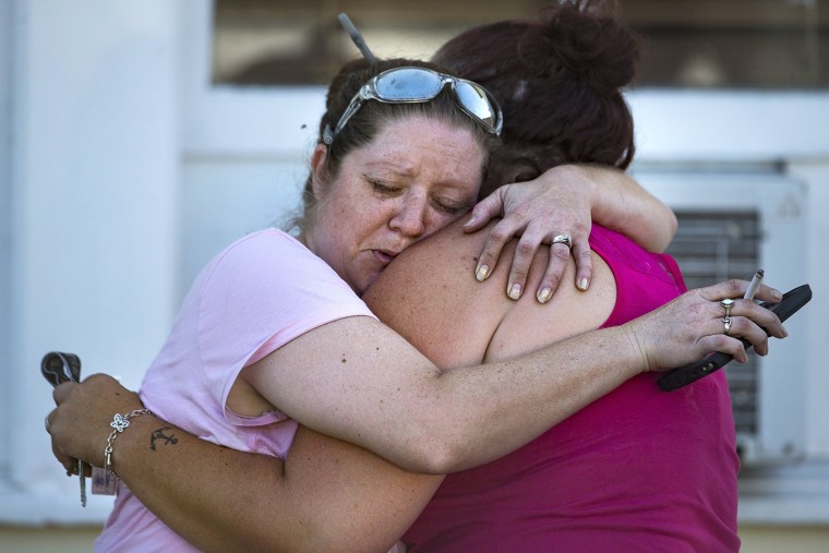 Image: Carrie Matula embraces a woman after a fatal shooting