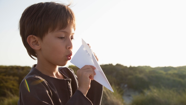 Boy making paper airplane