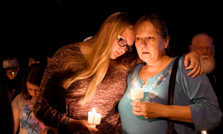 Image: Local residents embrace during a candlelight vigil for victims of a mass shooting in a church in Sutherland Springs, Texas
