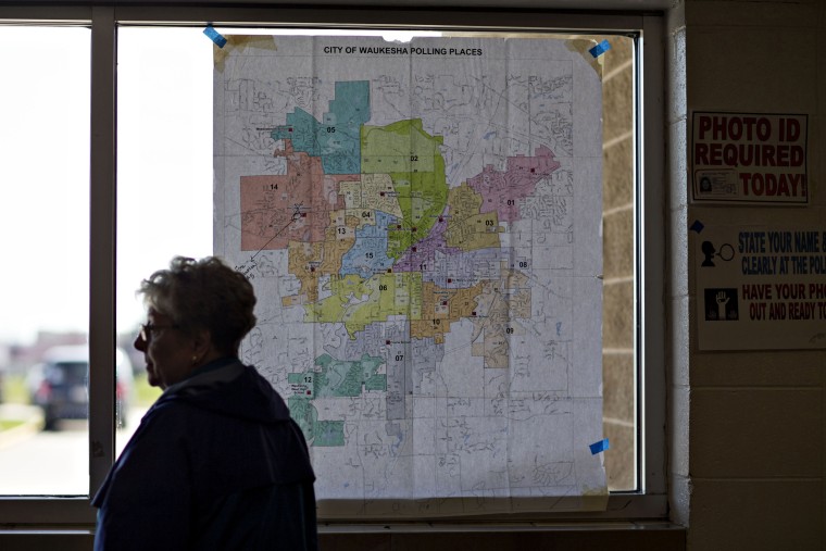 Image: A resident stands near a map of local polling places during the presidential primary vote