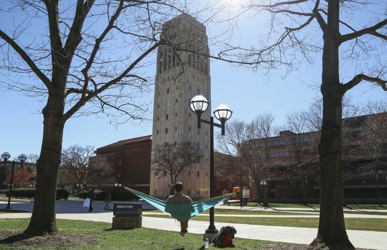 A student relaxes in front of Burton Tower on the University of Michigan campus in Ann Arbor.