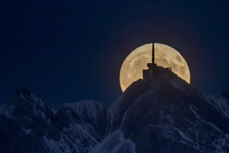 Image: The moon rises in front of the Saentis mountain near the village of Ebnat-Kappel, Switzerland